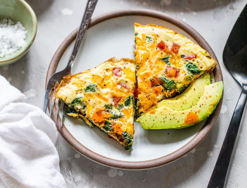 Egg white frittata with sliced avocados on a porcelain plate