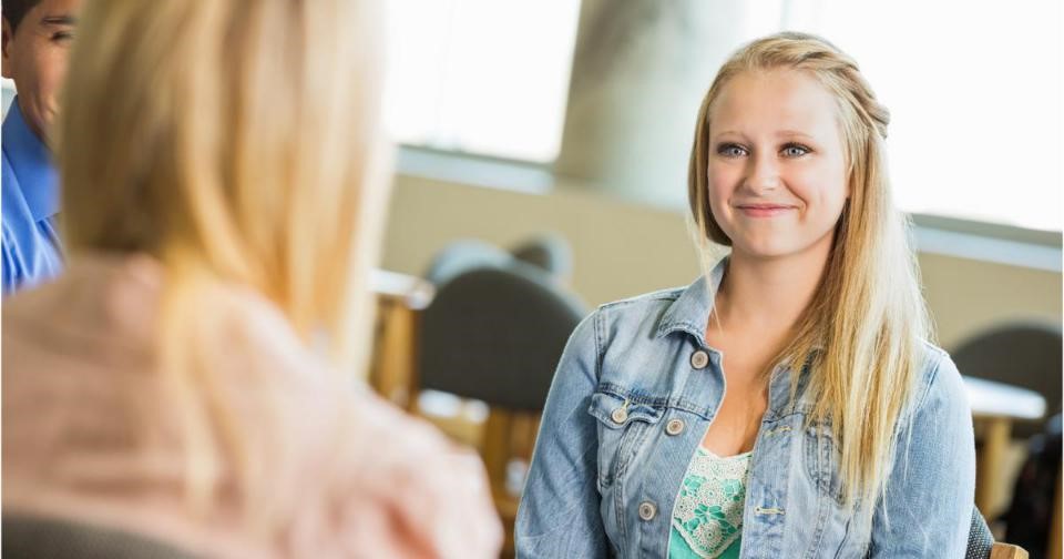 Teenage girl smiling in group therapy session.