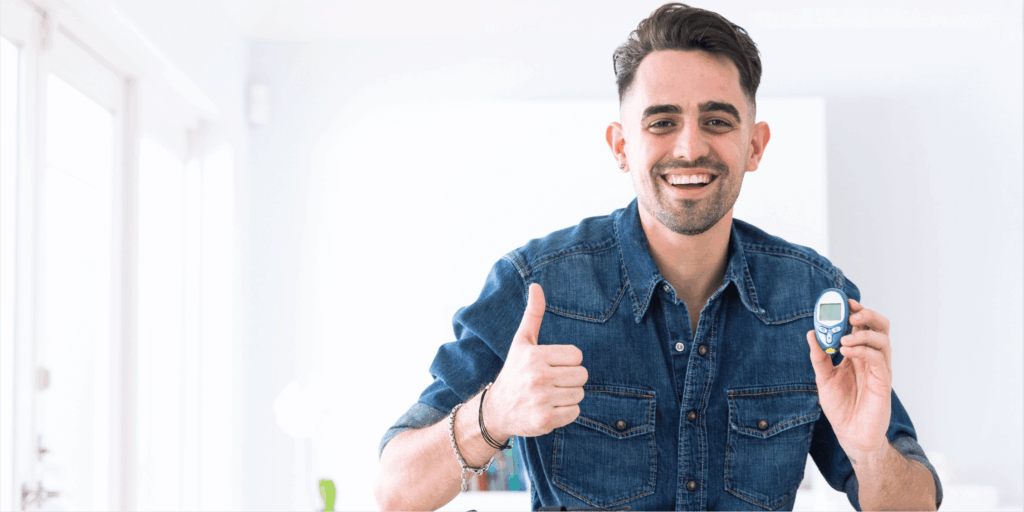 Smiling man proudly showing his low blood sugar levels on a glucose meter.