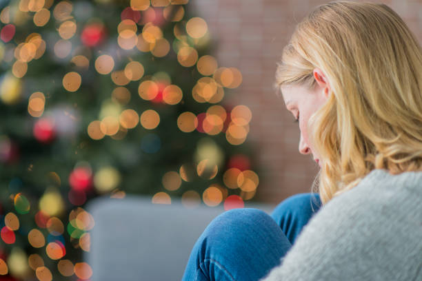 Woman sitting on the couch and looking sad on christmas day