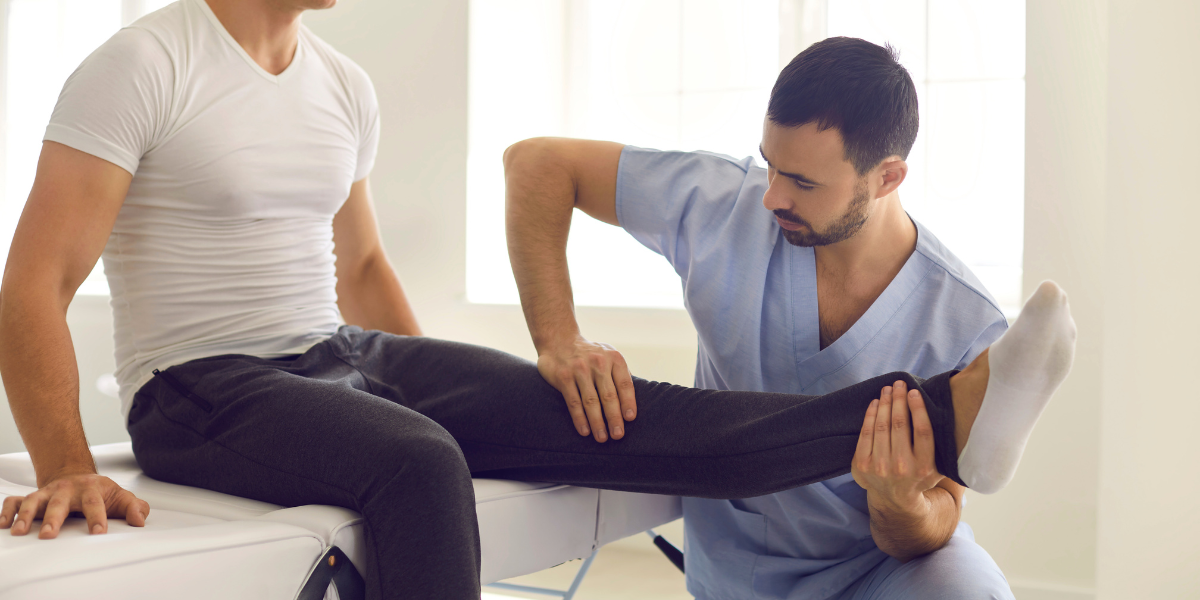 A chiropractor carefully adjusts an injured athlete's knee to provide relief and aid in the healing process.