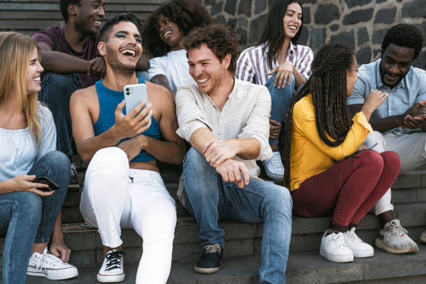 Young multiracial group of friends using mobile smartphone sitting on stairs youth millennial